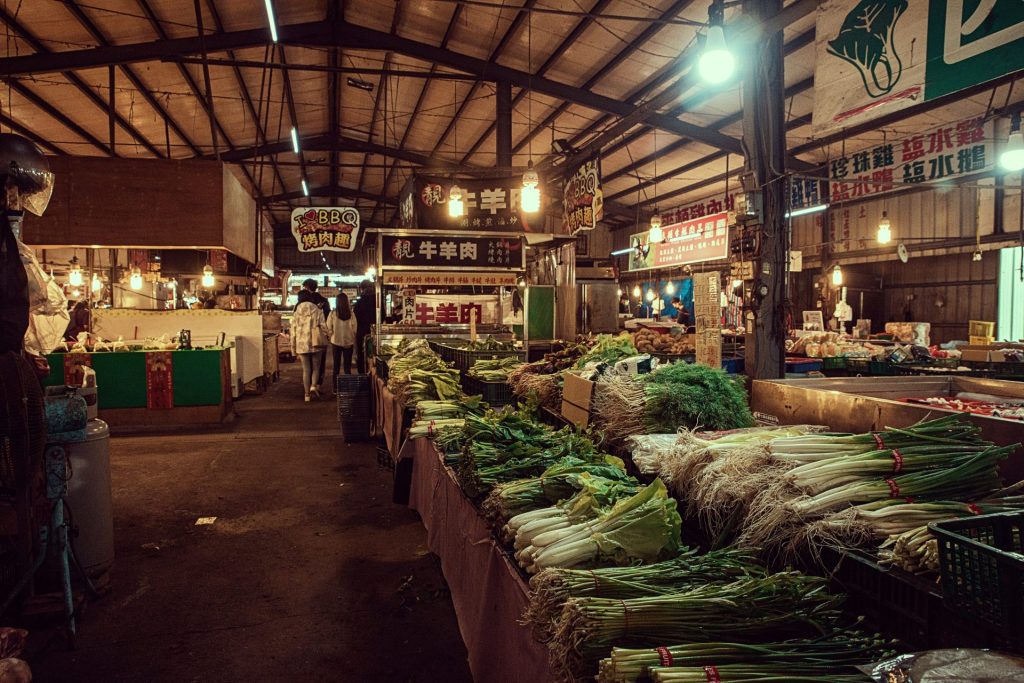 an indoor market with a variety of vegetables